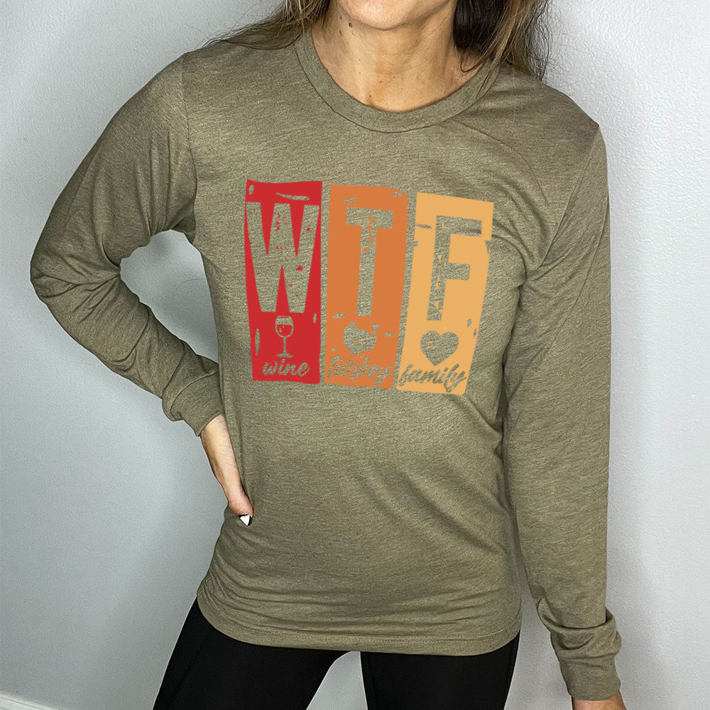 heather olive long sleeve shirt with a graphic on it that says "WTF" and under the "W" there's a graphic of a wine glass and the word "wine"; under "T" there's a graphic of a turkey and the word "turkey"; under F there's a graphic of a heart and the word "family"