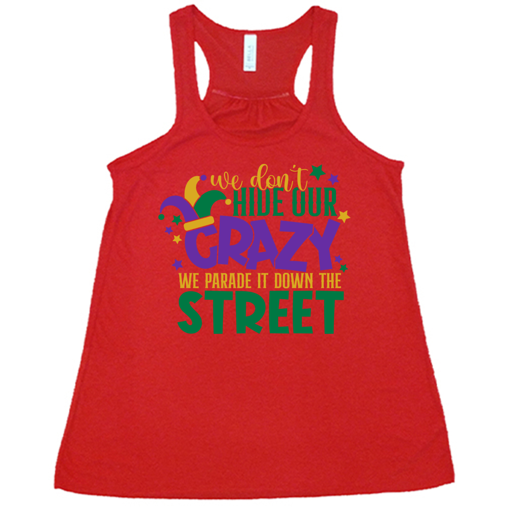 red flowy tank with the words "we don't hide our crazy we parade it down the street" on it with a joker hat on the letter "c" and a few little stars scattered around