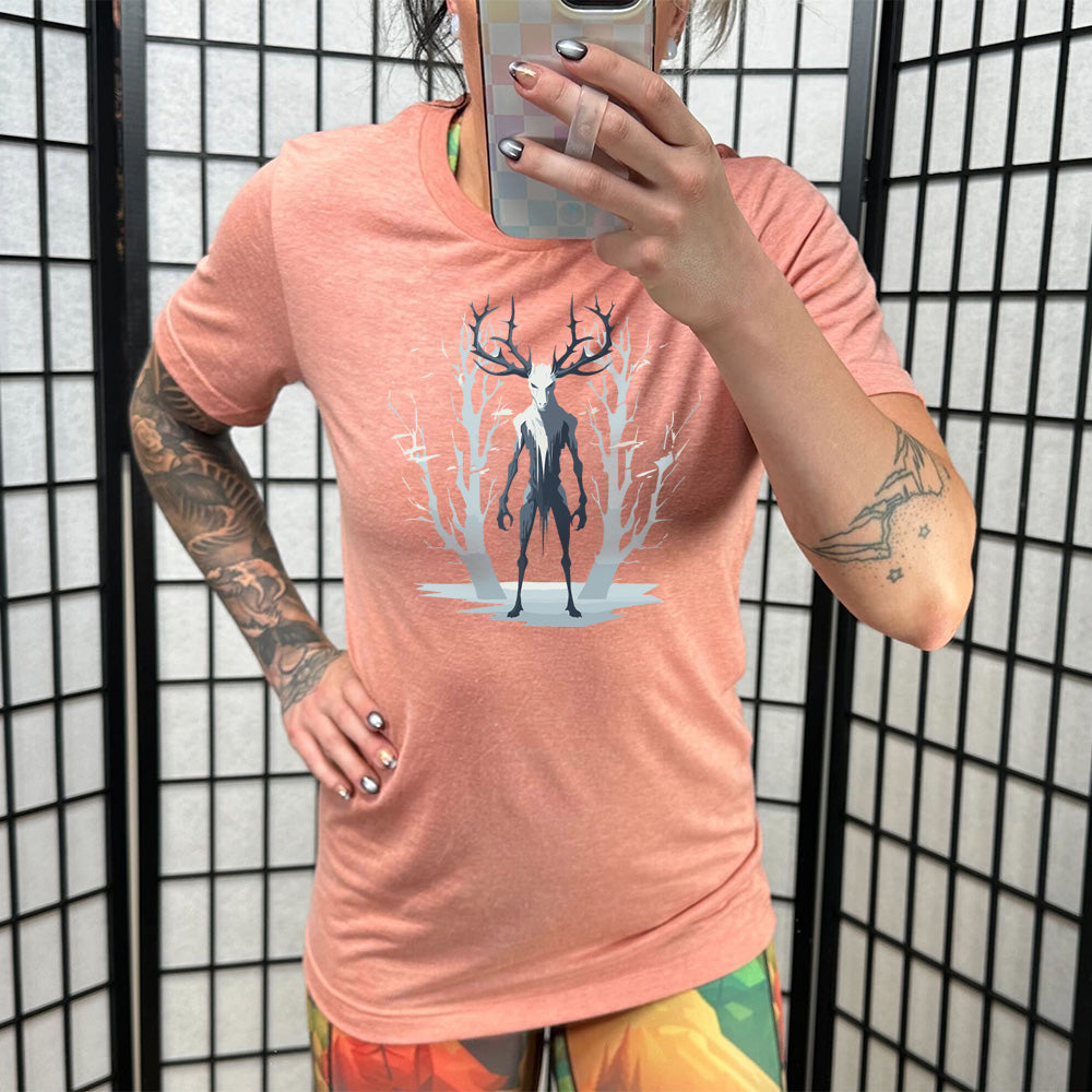 Model wearing sunset colored shirt with wendigo in the woods graphic on it