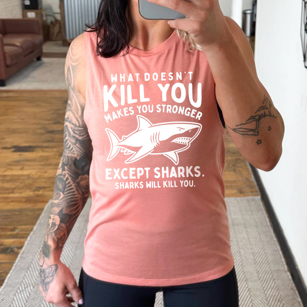 peach muscle tank with the words "what doesn't kill you makes you stronger except sharks. sharks will kill you." and the graphic of a fierce shark in the middle