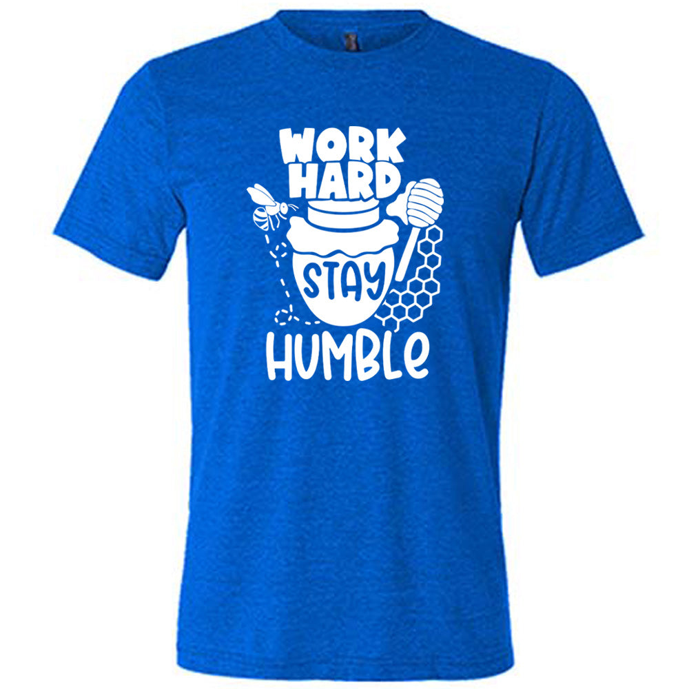 blue unisex tee with the words "work hard stay humble" on it, with the word "stay" on the graphic of a honeypot, and a bee flying around the pot's left, and some honeycomb and a honey spoon on its right
