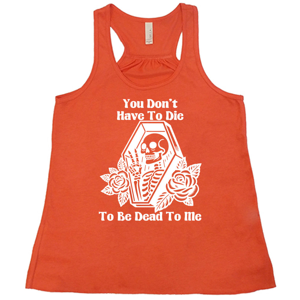coral flowy tank with the words "You don't have to die to be dead to me" on it with the graphic of a a skeleton in a coffin, giving the peace sign, with two flowers on either side of the coffin