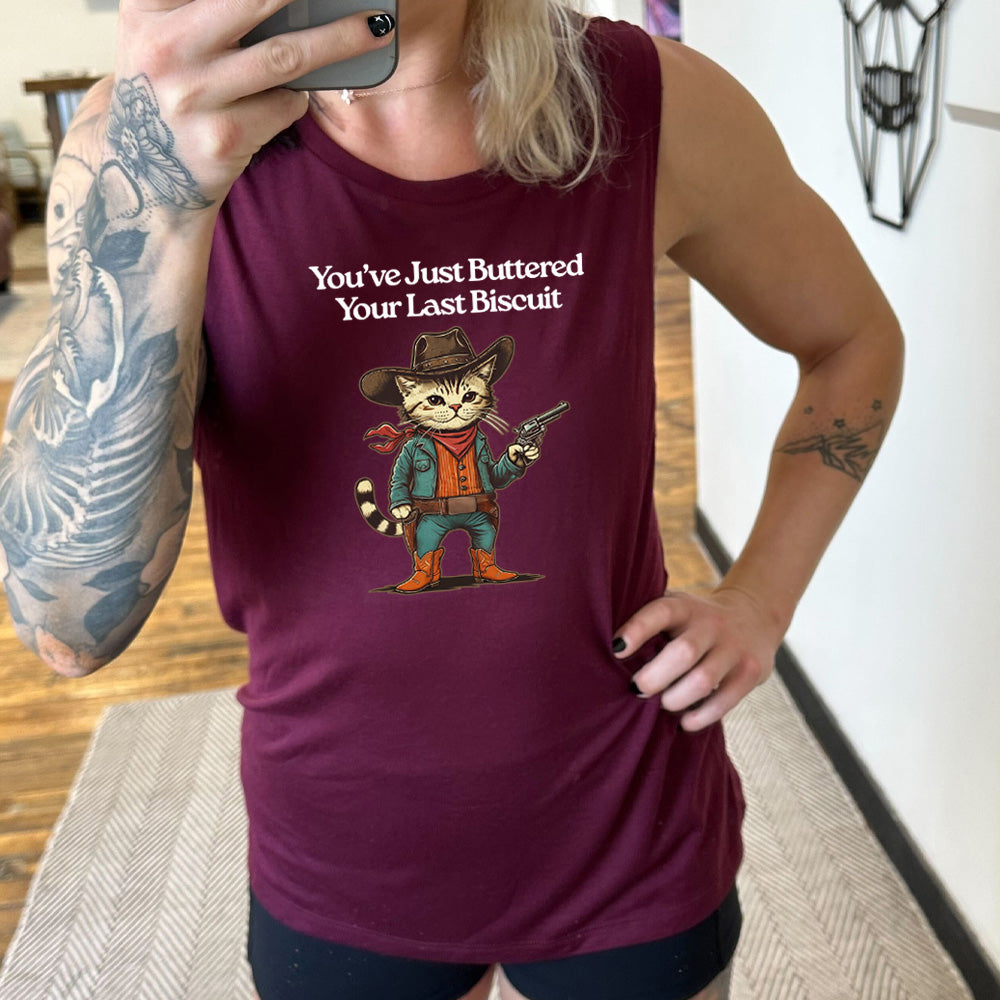 maroon muscle tank with a cat wearing a cowboy hat graphic on it that says "You've Just Buttered Your Last Biscuit"