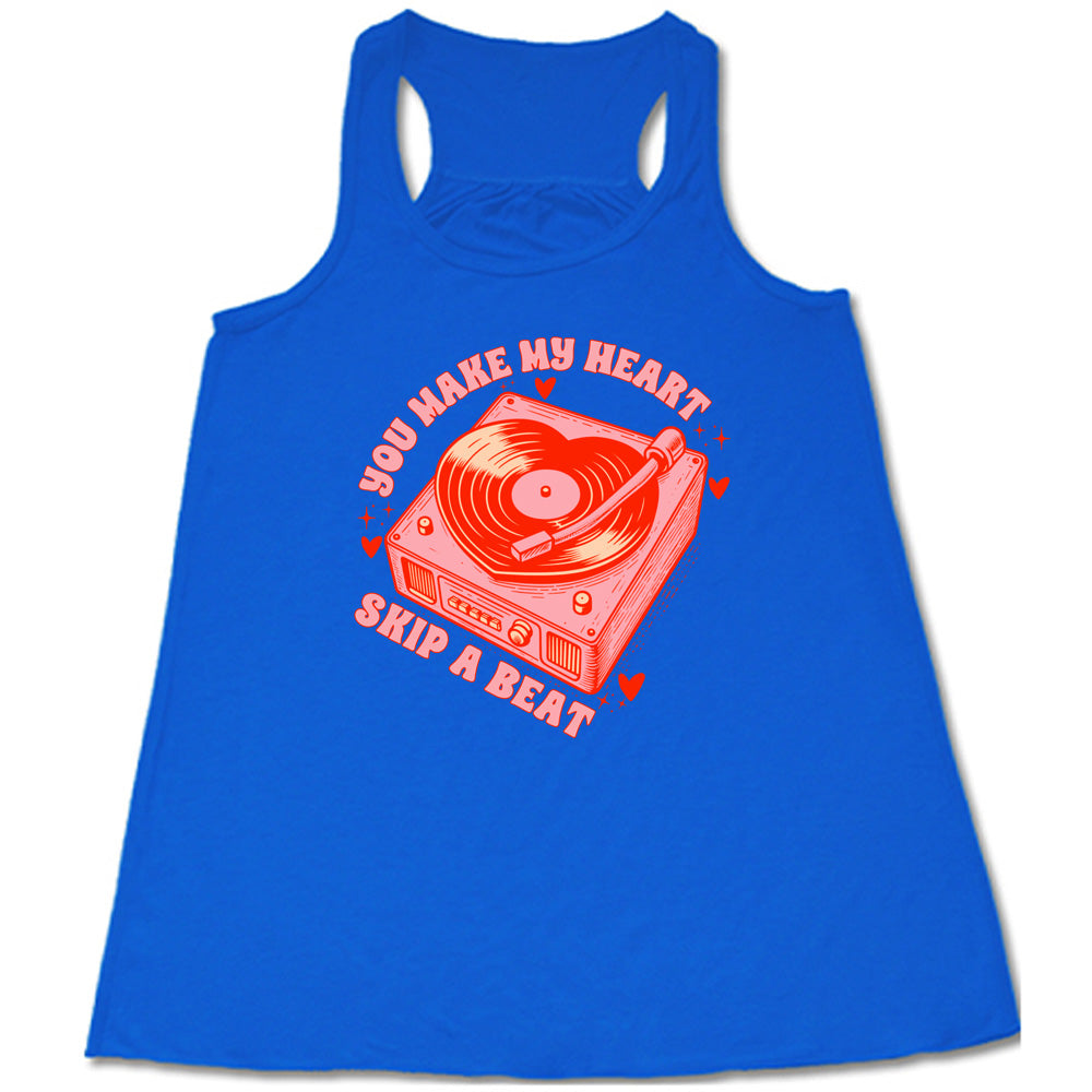 blue flowy shirt with the words "you make my heart skip a beat" on it, with the graphics of a record player, with a record shaped like a heart, with a little hearts and stars around each corner of the player