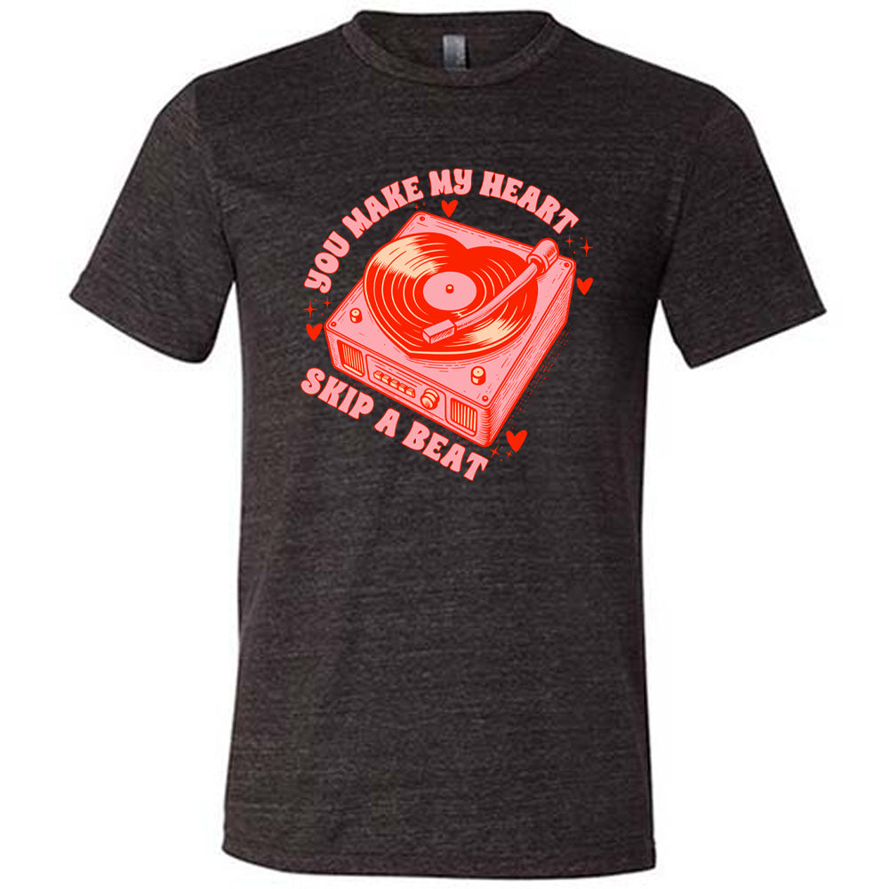 black unisex tee with the words "you make my heart skip a beat" on it, with the graphics of a record player, with a record shaped like a heart, with a little hearts and stars around each corner of the player