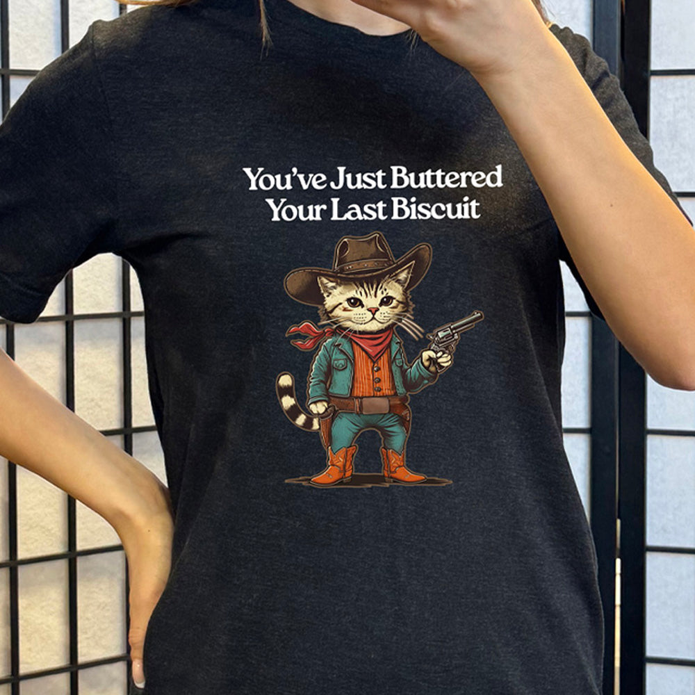 Black colored shirt with a cowboy cat graphic on it that says "You've Just Buttered Your Last Biscuit"