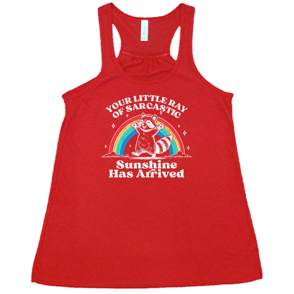 Red colored flowy tank with a rainbow and raccoon graphic on it that says "Your Little Ray of Sarcastic Sunshine Has Arrived"