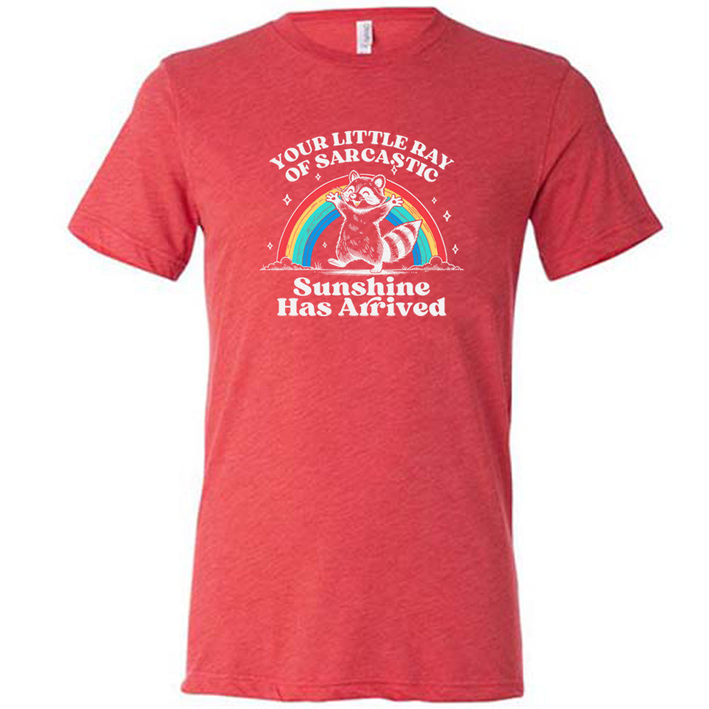 Red colored shirt with a rainbow and raccoon graphic on it that says "Your Little Ray of Sarcastic Sunshine Has Arrived"