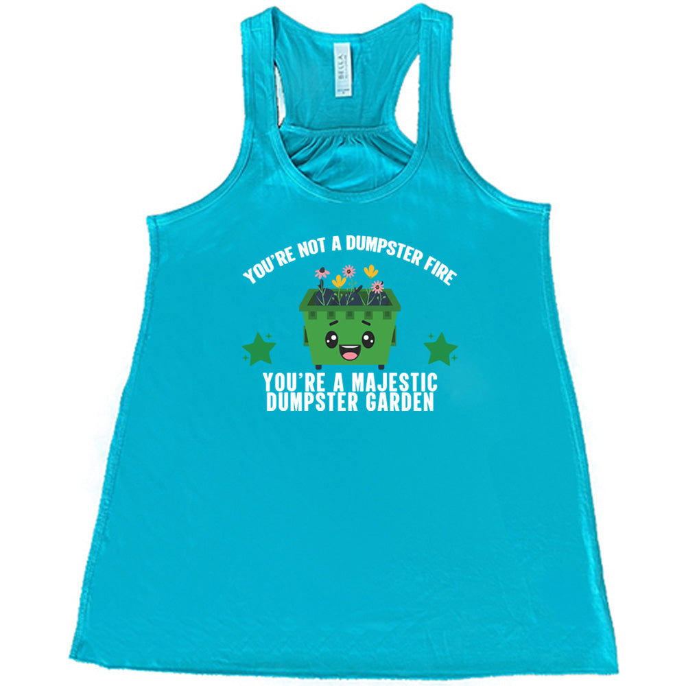 Teal colored flowy tank with a dumpster and flowers graphic on it that says "You're Not A Dumpster Fire, You're A Majestic Dumpster Garden"