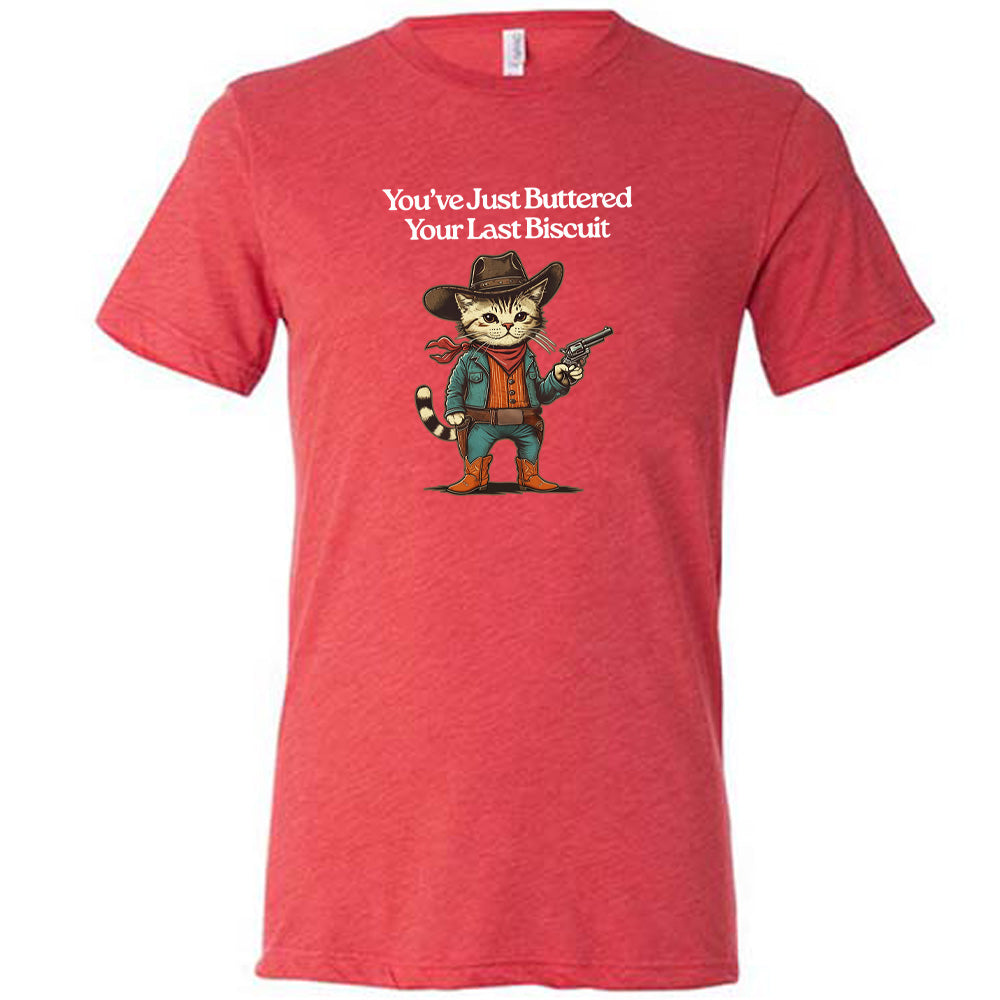 Red colored shirt with a cowboy cat graphic on it that says "You've Just Buttered Your Last Biscuit"