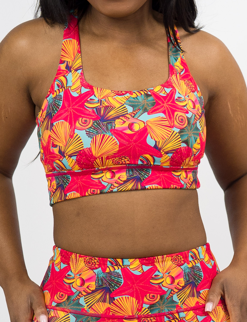 front of the red starfish with a yellow and blue shell background longline bra against a white background