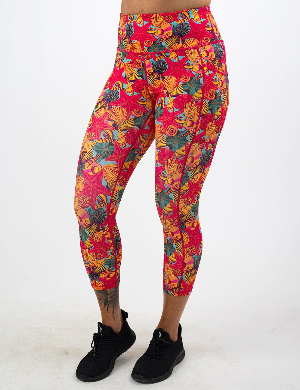 front of the front of the red starfish with a yellow and blue shell background capri leggings against a white background
