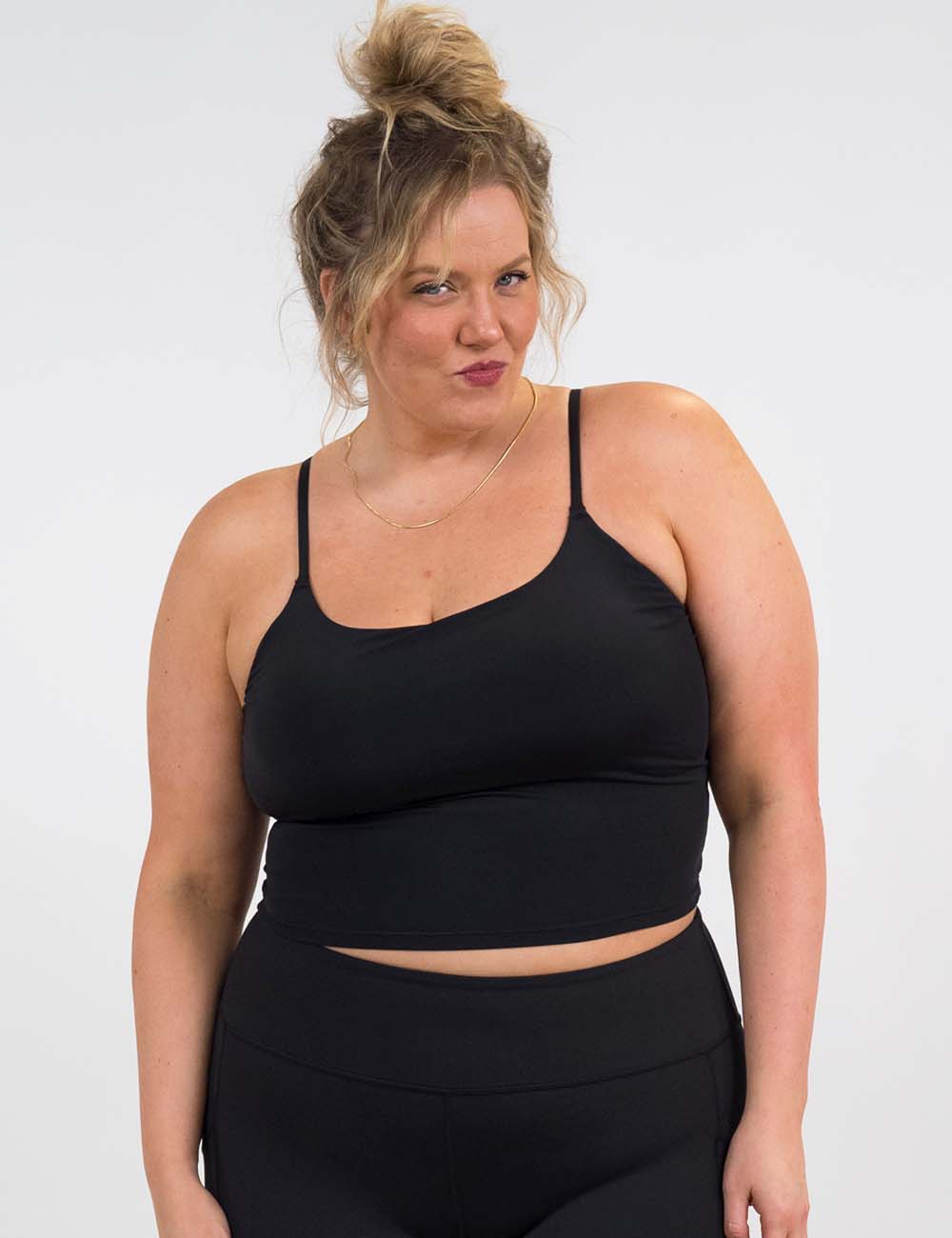 model wearing the black cami top against a white background