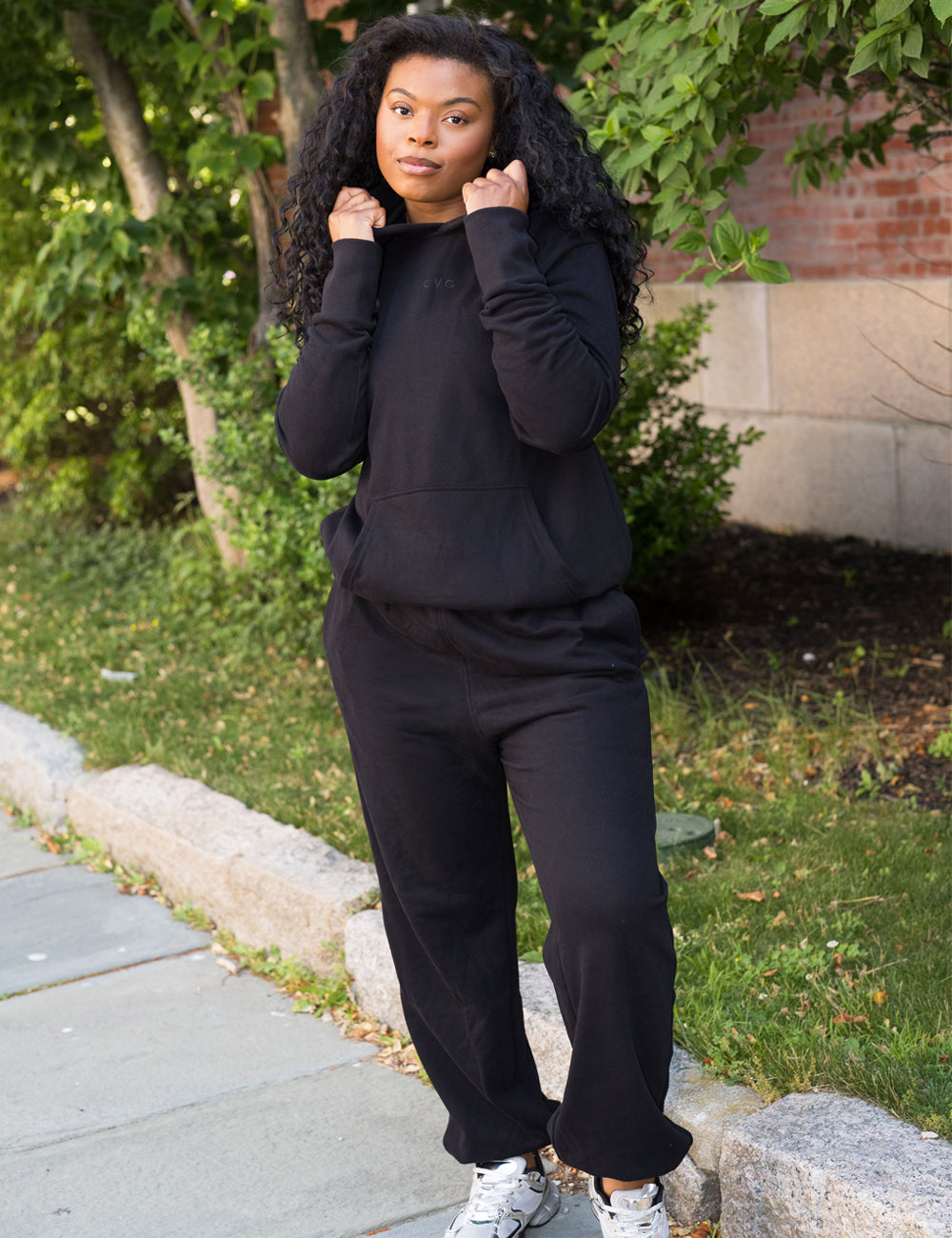 model wearing black sweatsuit