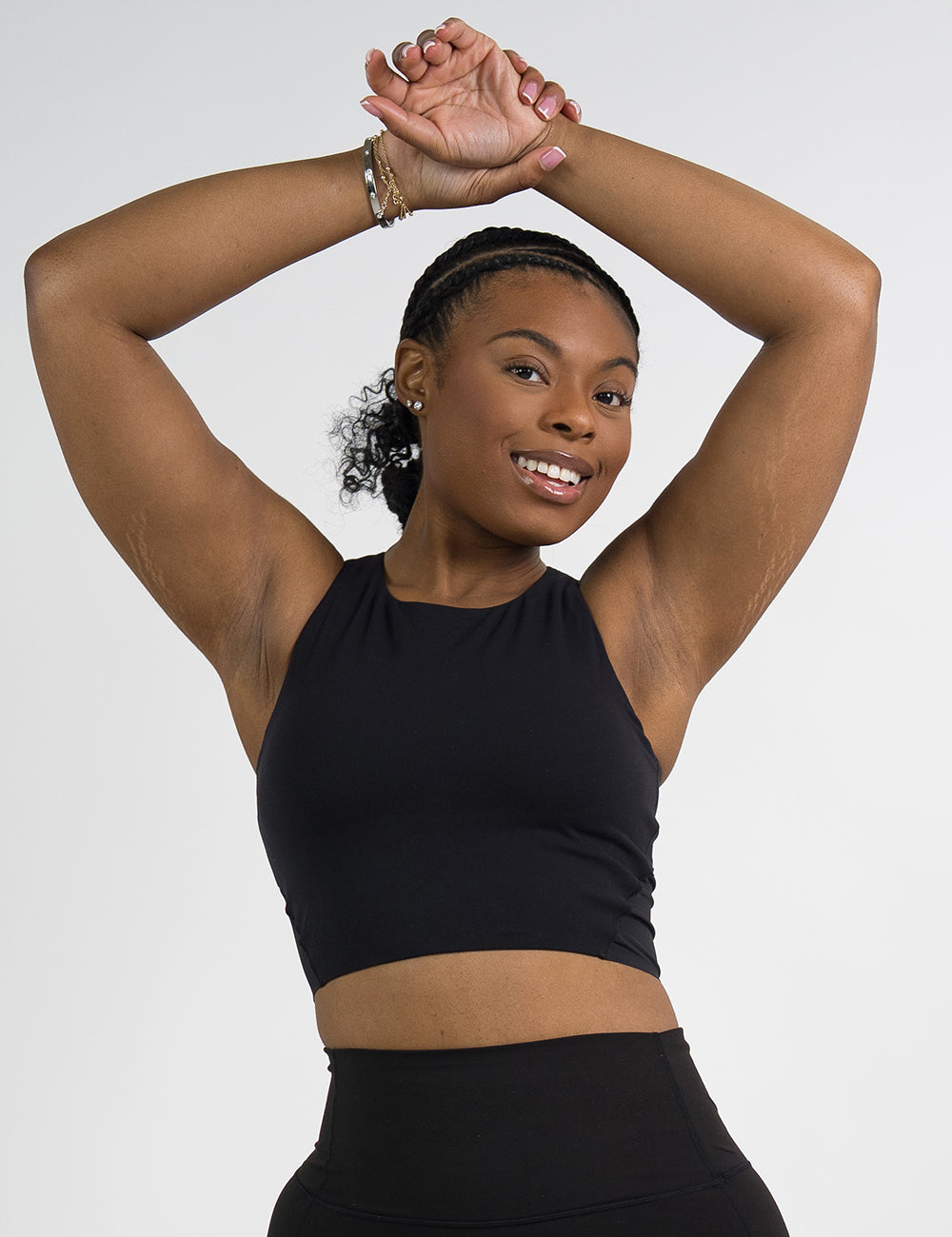 model wearing the black cropped tank top against a white background