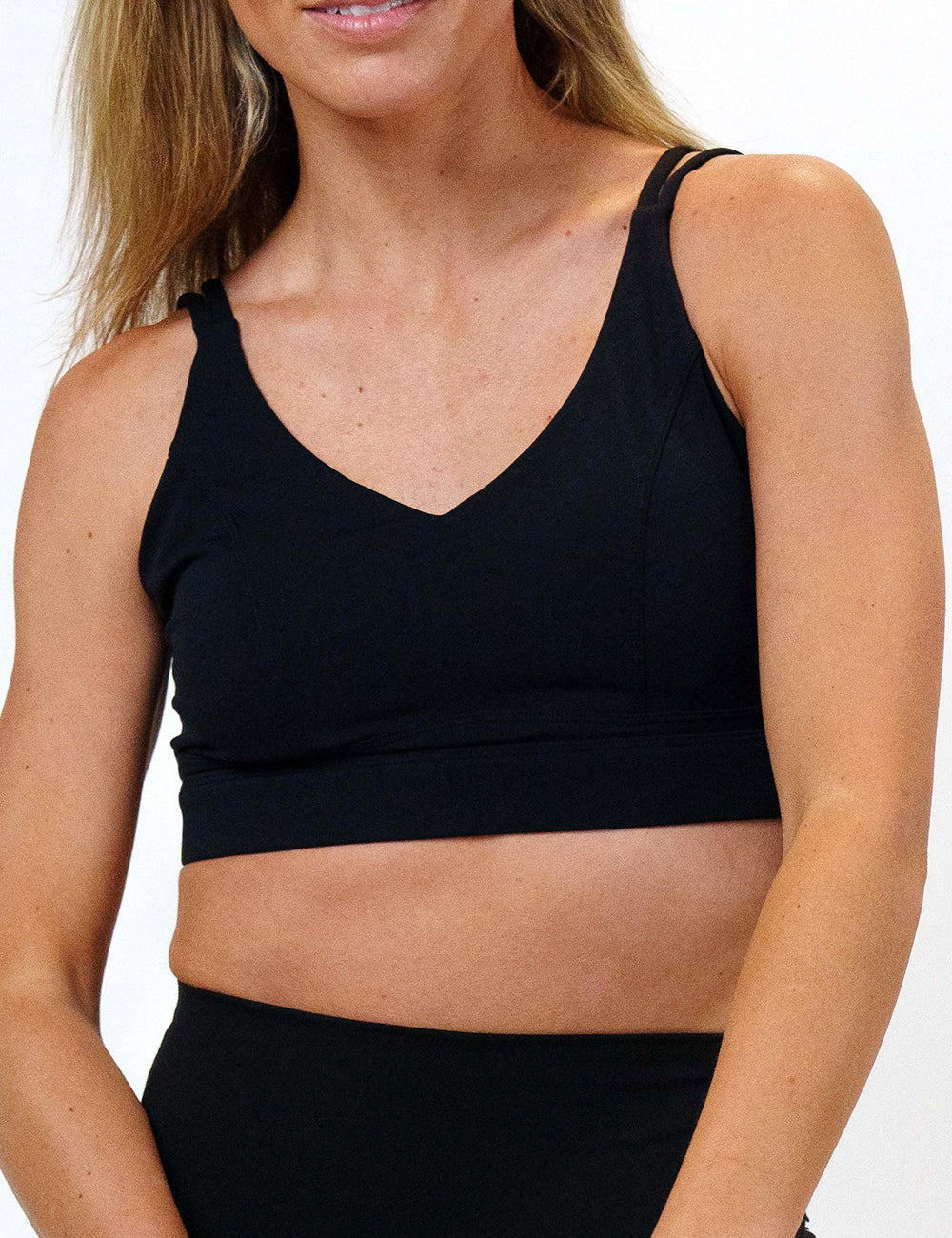 front of the solid black sports bra against a white background