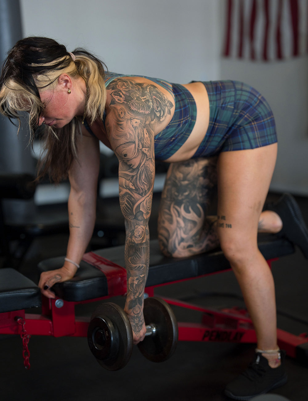 model wearing the blue, green, and yellow plaid 2.5 inch shorts working out in the gym
