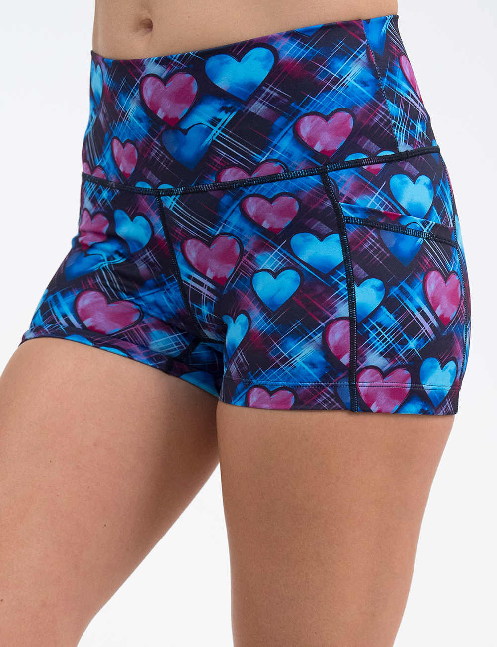 close up of the 2.5 inch blue and pink hearts pattern against a dark stitched background shorts against a white background