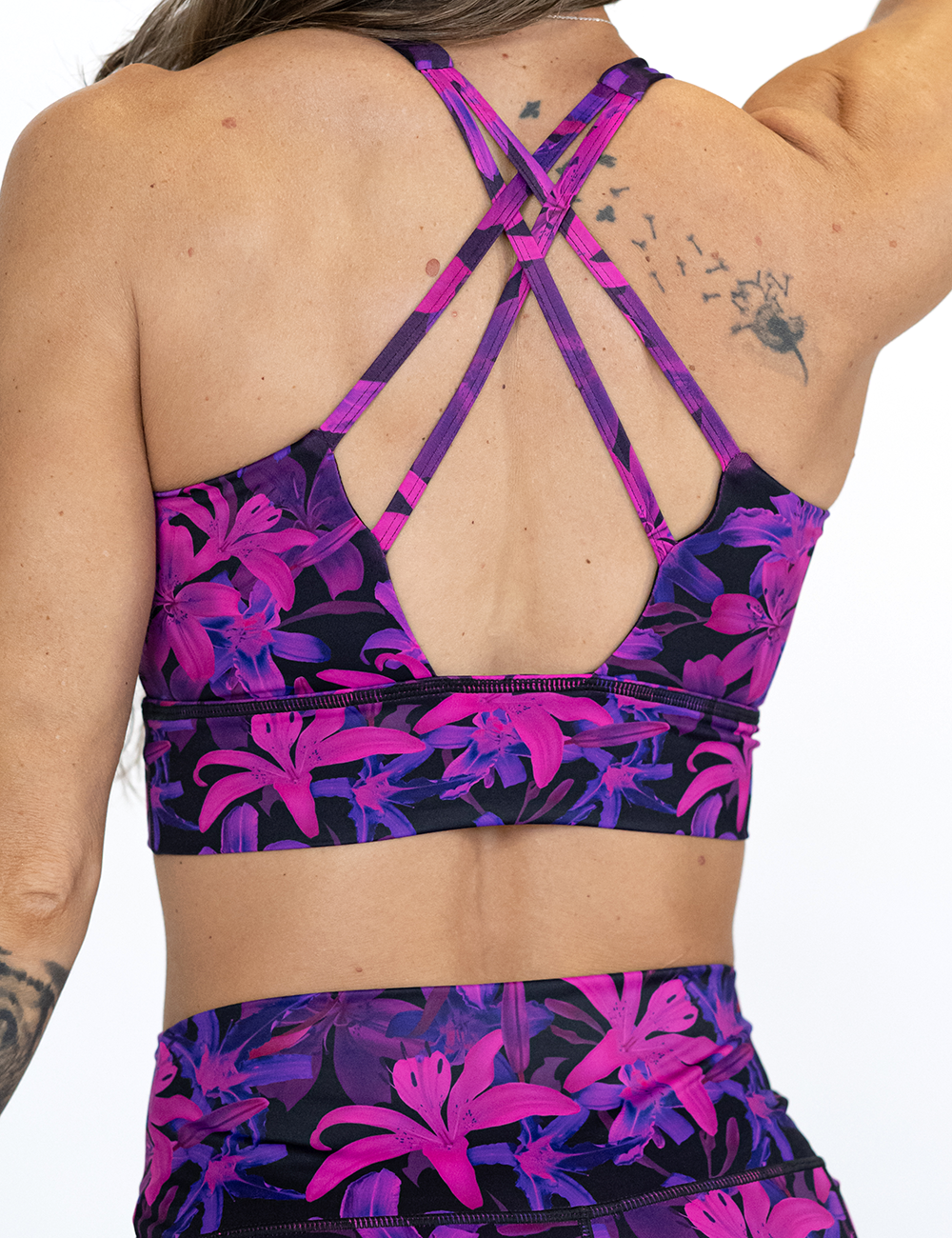 back of the vibrant purple flower longline bra against a white background