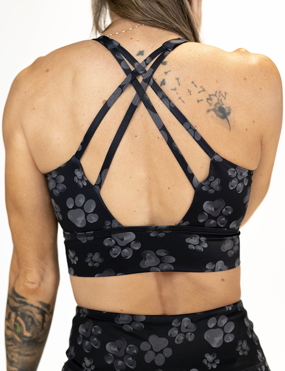 back of the grey pawprint against a black background longline bra