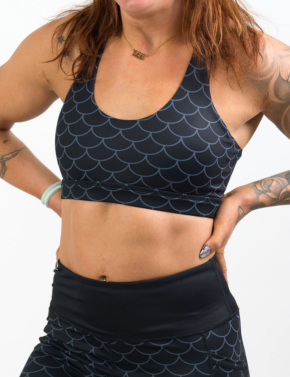 front of the dragon scale outline against a dark background pattern butterfly back bra against a white background