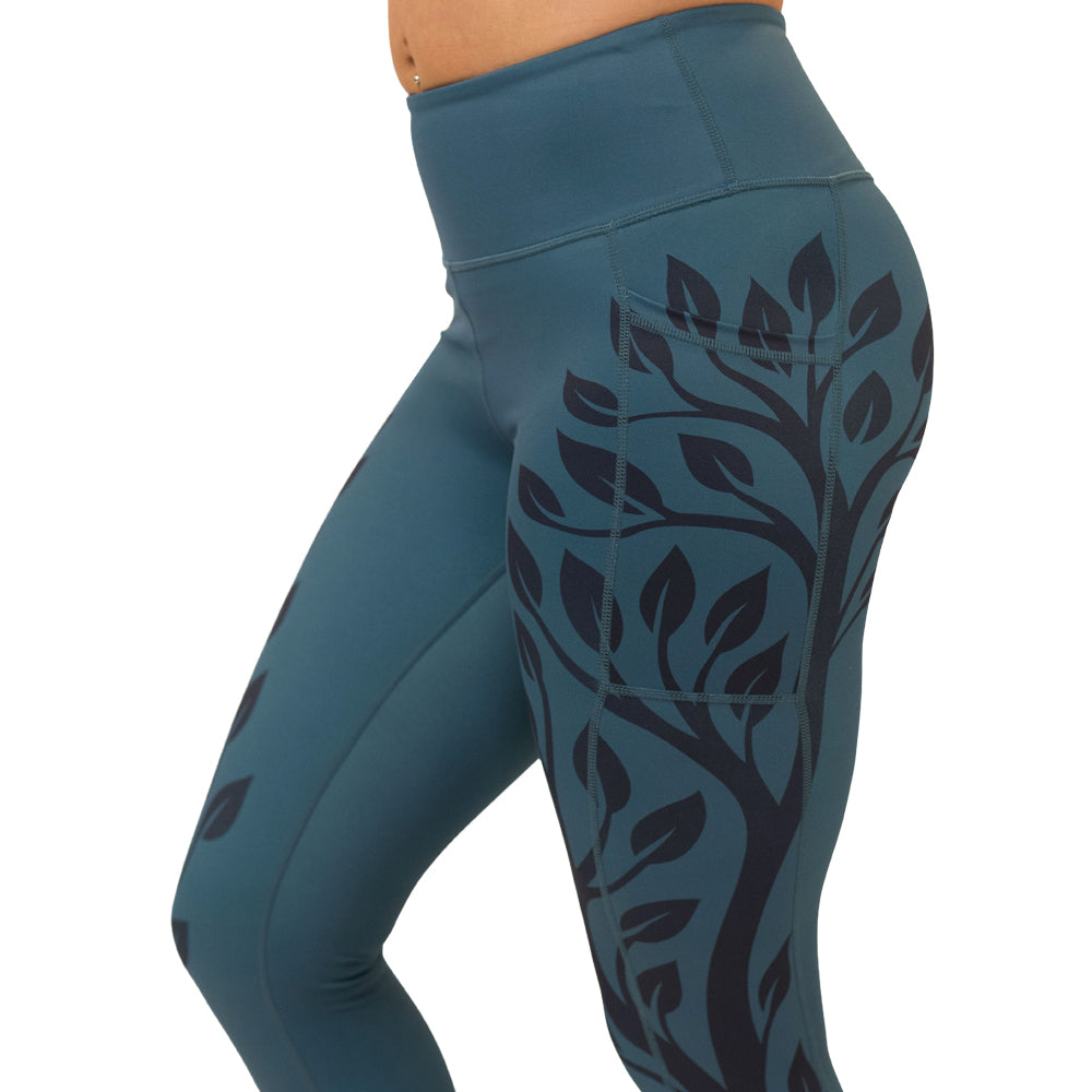 Teal leggings with black branch pattern on a white background