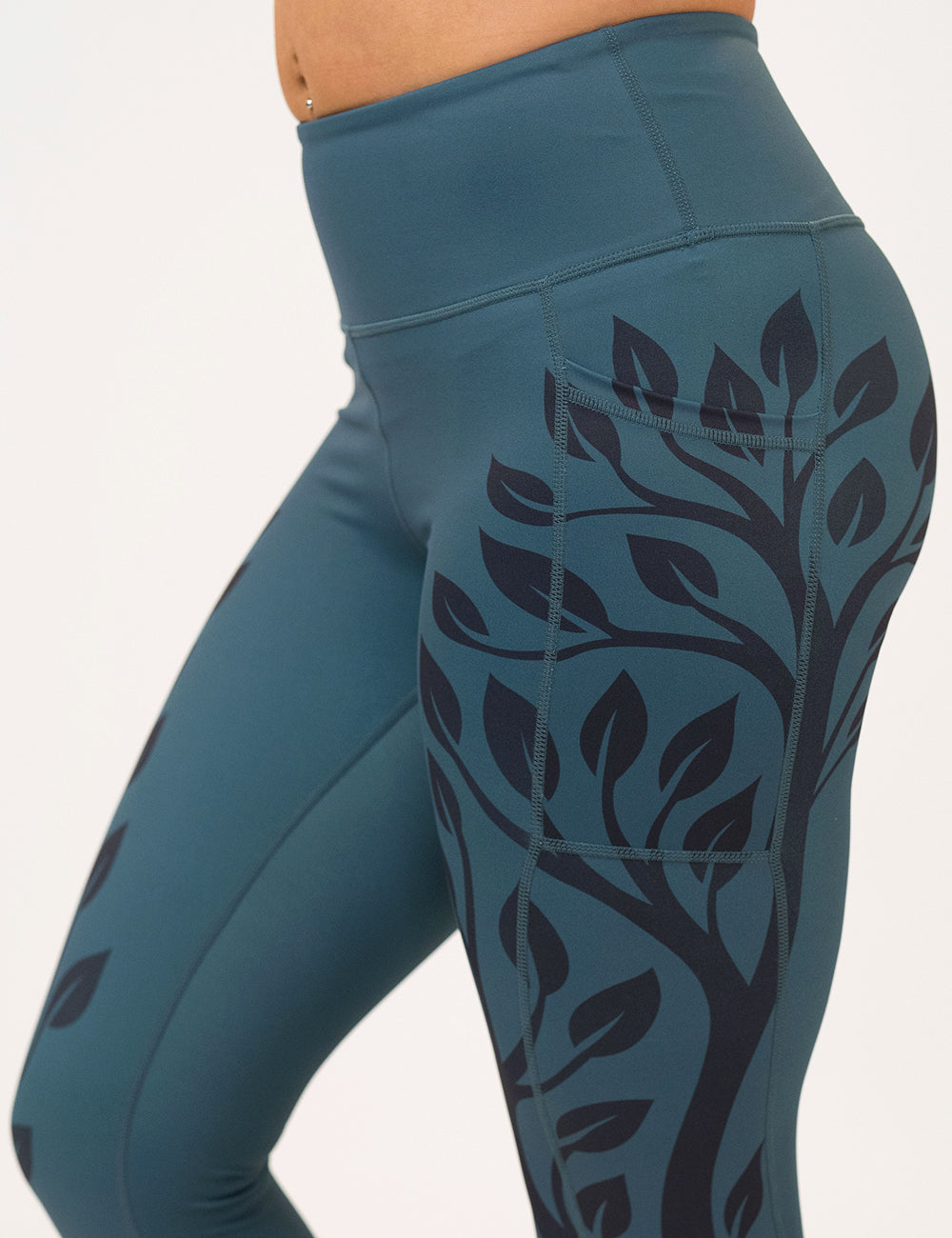 Teal leggings with black branch pattern on a white background