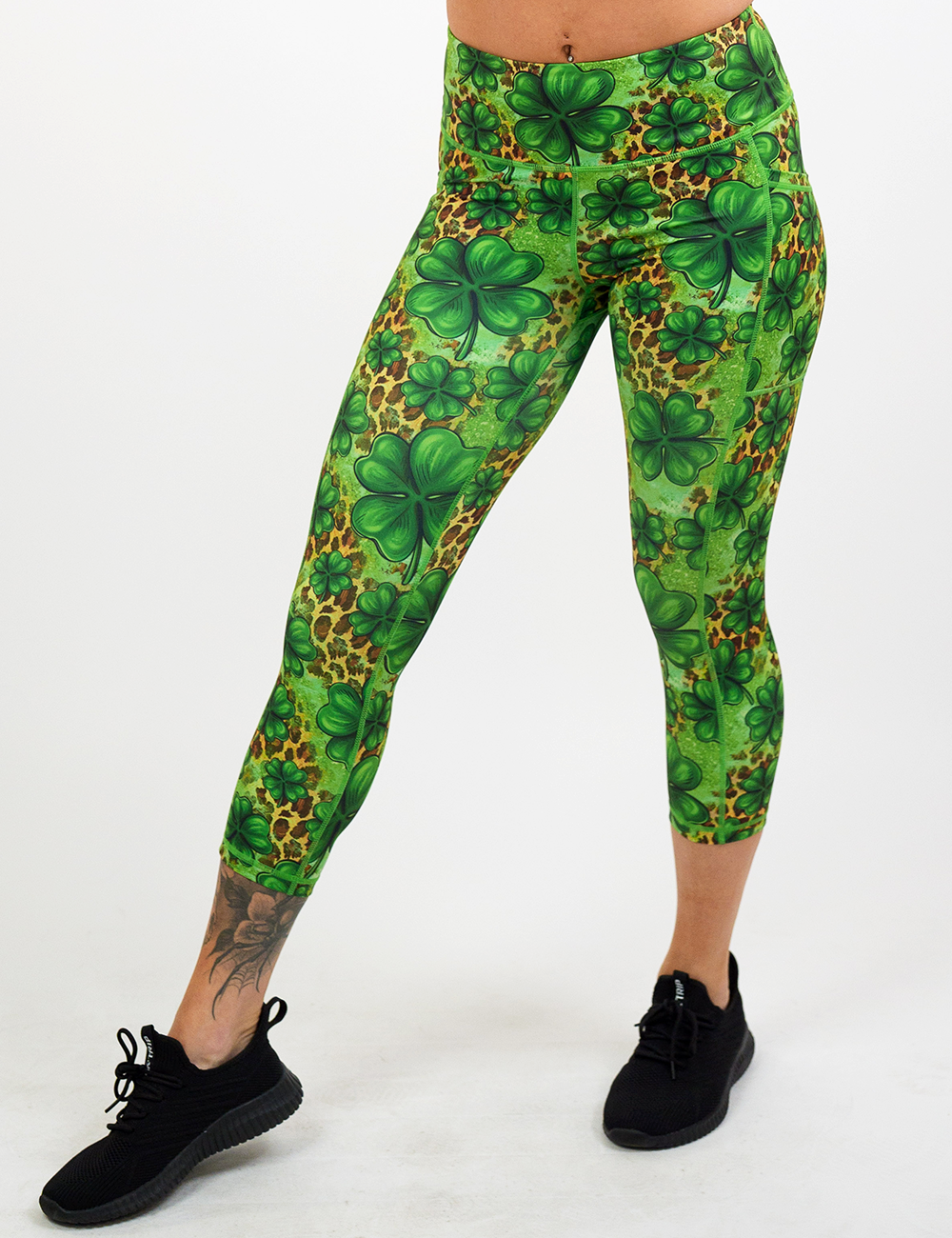 model wearing the clover pattern against a cheetah print and green background capri leggings against a white background