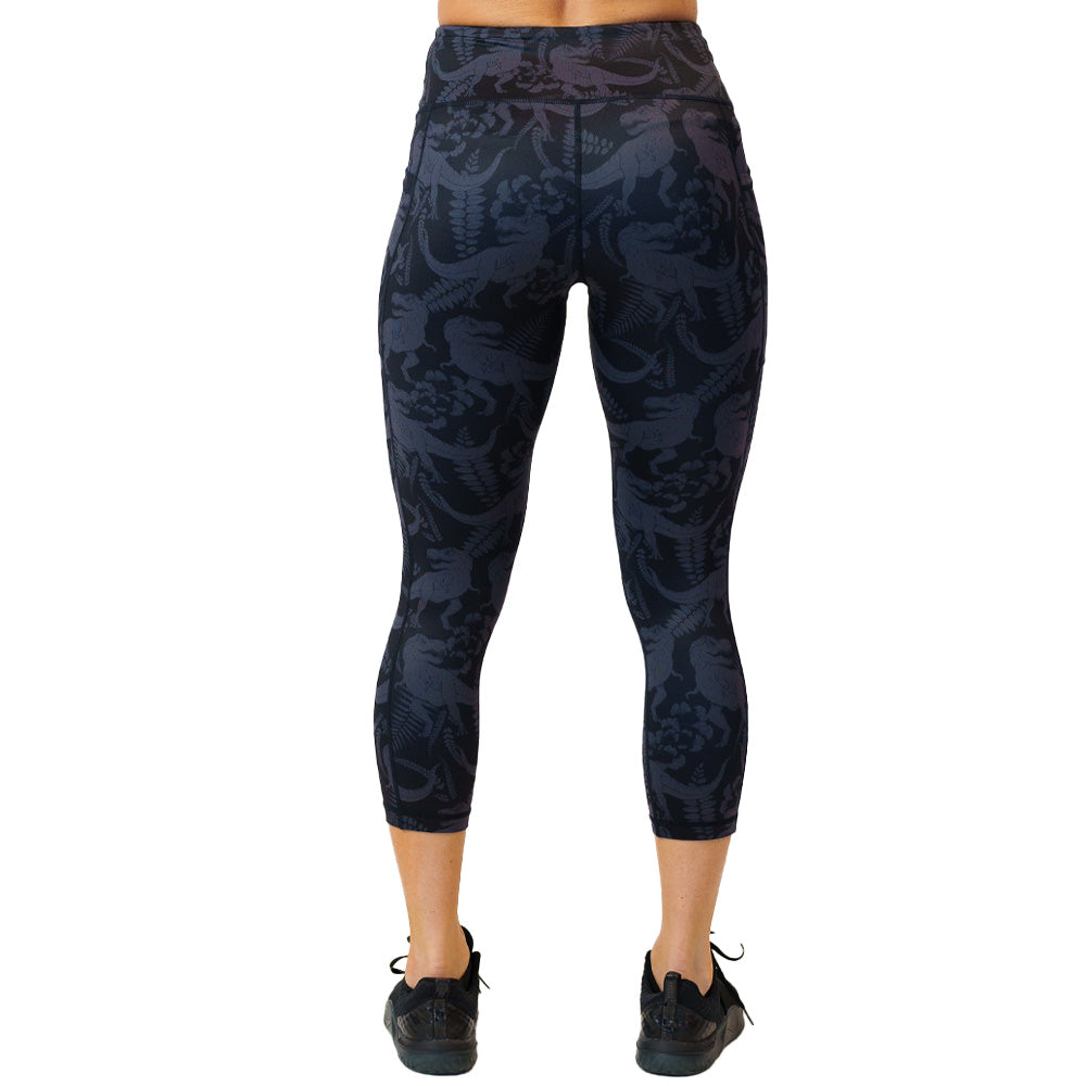 back view of capri length black leggings with grey dinosaur pattern