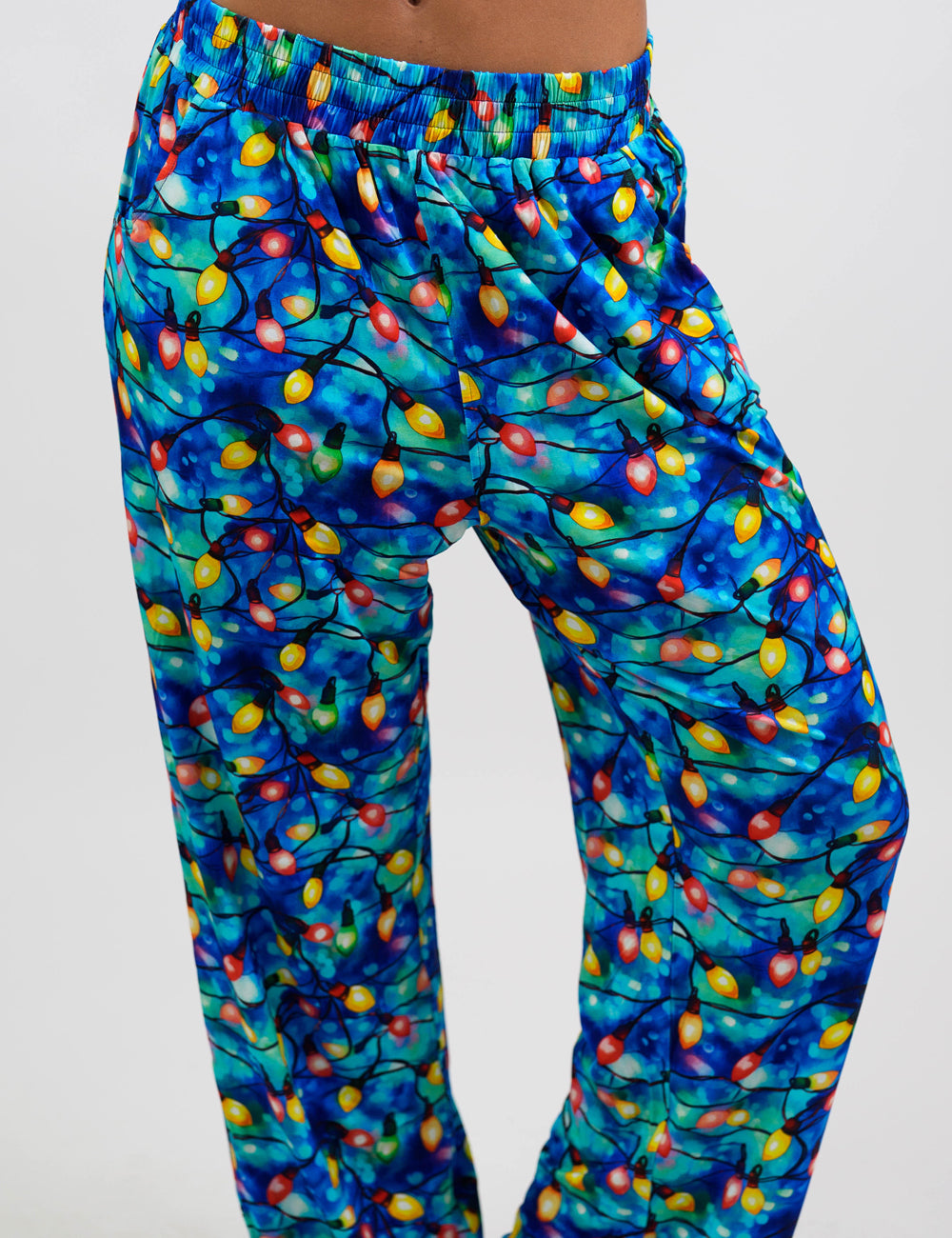 close up of the Christmas lights in front of blue and teal background pajama bottoms, coming October 23