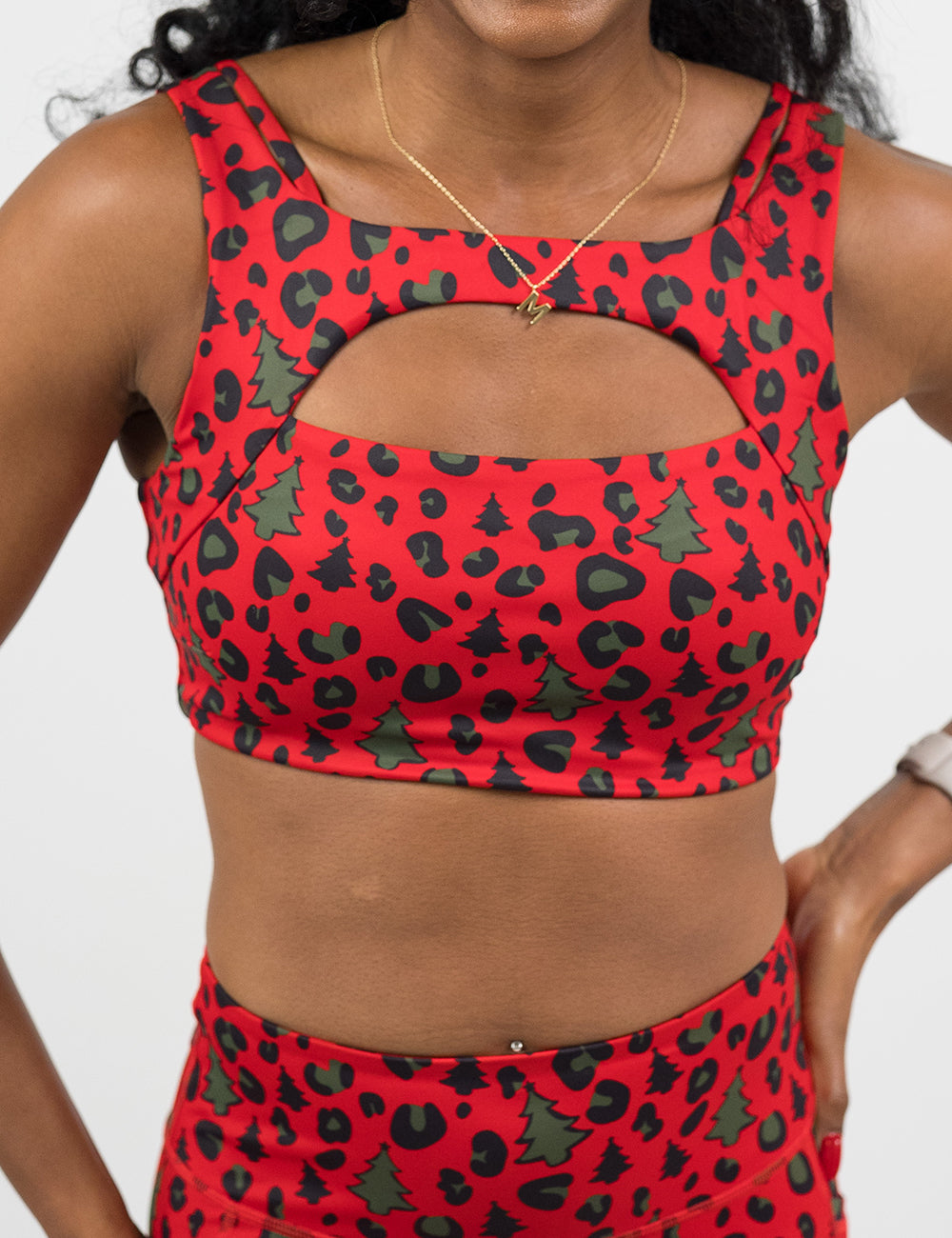 front of the red and brown Christmas trees and leopard print sports bra