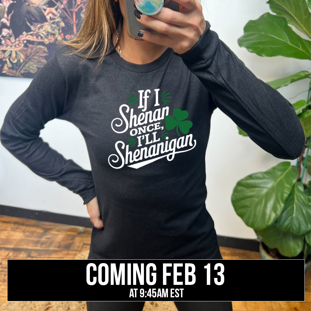heather black long sleeve with the words "if I shenan once, I'll shenanigan" on it, with the graphic of a shamrock, coming soon
