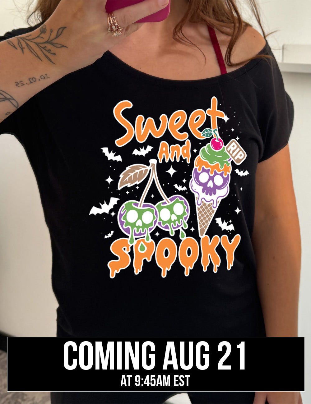 black slouchy tee with the graphic of two cherries on the same branch, with a skull dripping on each of them, and a cherry-topped ice cream cone, with one of the scoops being a skull, with a little "RIP" sign sticking out of the cone, surrounded by bats and stars, and the words starting on top and ending below the graphics saying "sweet and spooky", coming august 21st