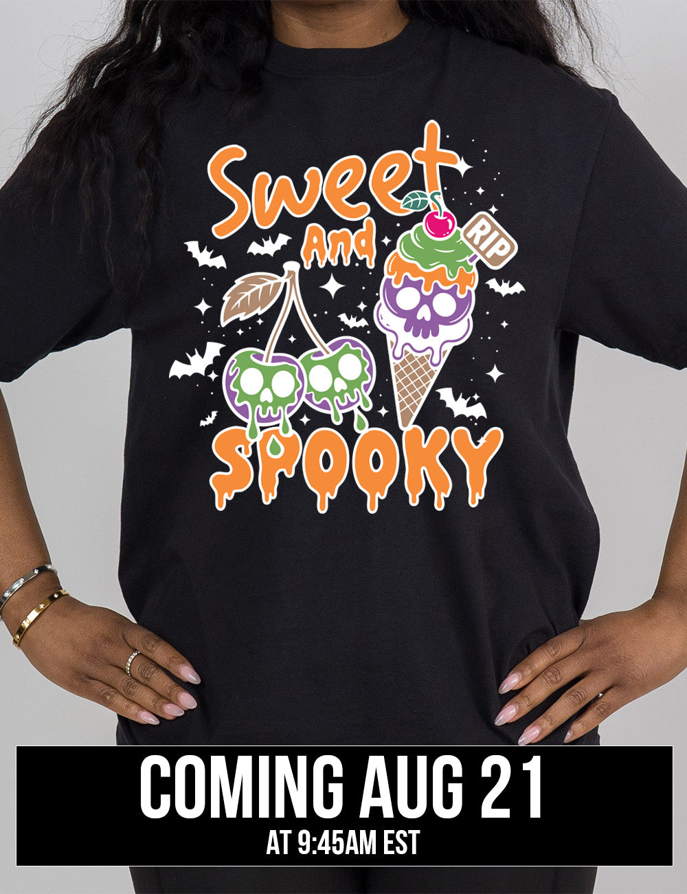black modern tee with the graphic of two cherries on the same branch, with a skull dripping on each of them, and a cherry-topped ice cream cone, with one of the scoops being a skull, with a little "RIP" sign sticking out of the cone, surrounded by bats and stars, and the words starting on top and ending below the graphics saying "sweet and spooky", coming august 21st