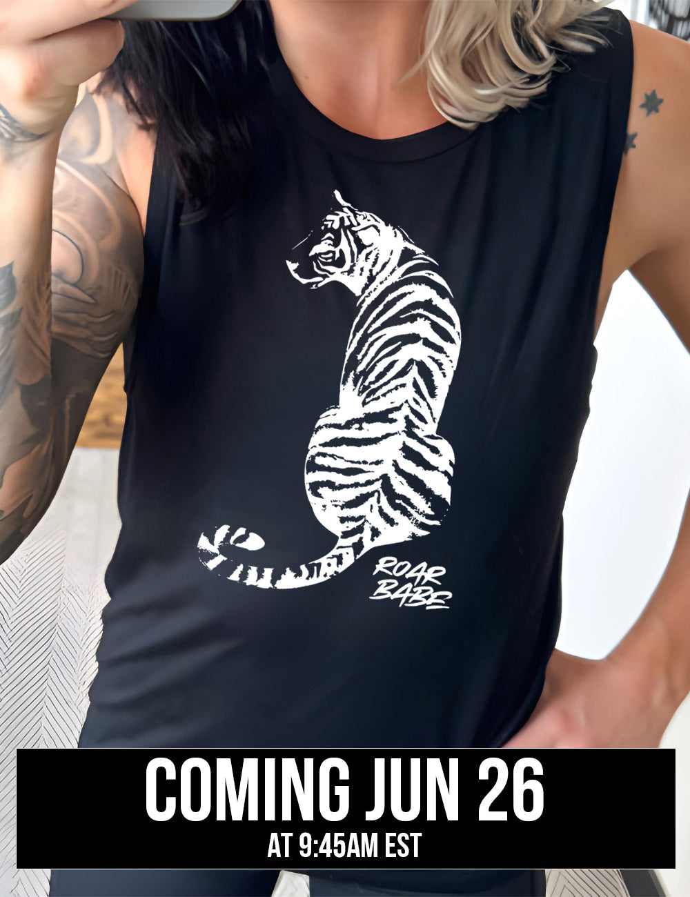 black muscle tank with the graphic of a tiger, from the back, sitting, looking to one side, with the words "roar babe" in small font underneath, coming june 26th