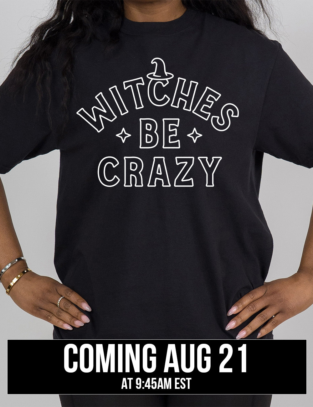 black modern tee with the words in outline font saying "witches be crazy" with a witch hat on top of the "c" in "witches" and a star on either side of the word "be", coming august 21st