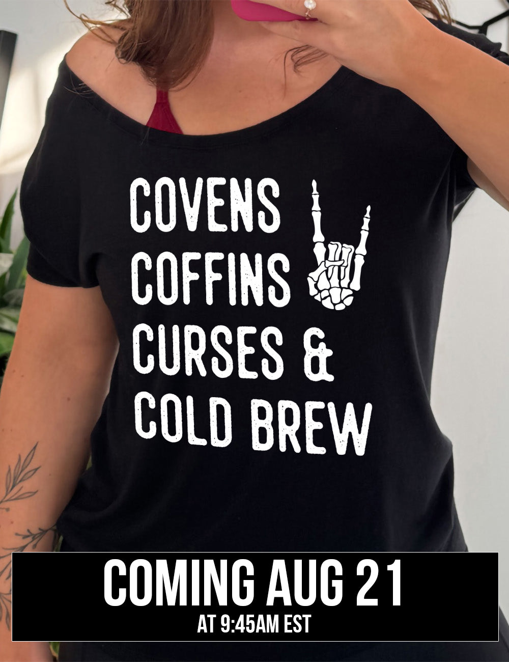 black slouchy tee with the words listed "covens coffins curses & cold brew" and the graphic of a skeletal rocker hand, coming august 21st