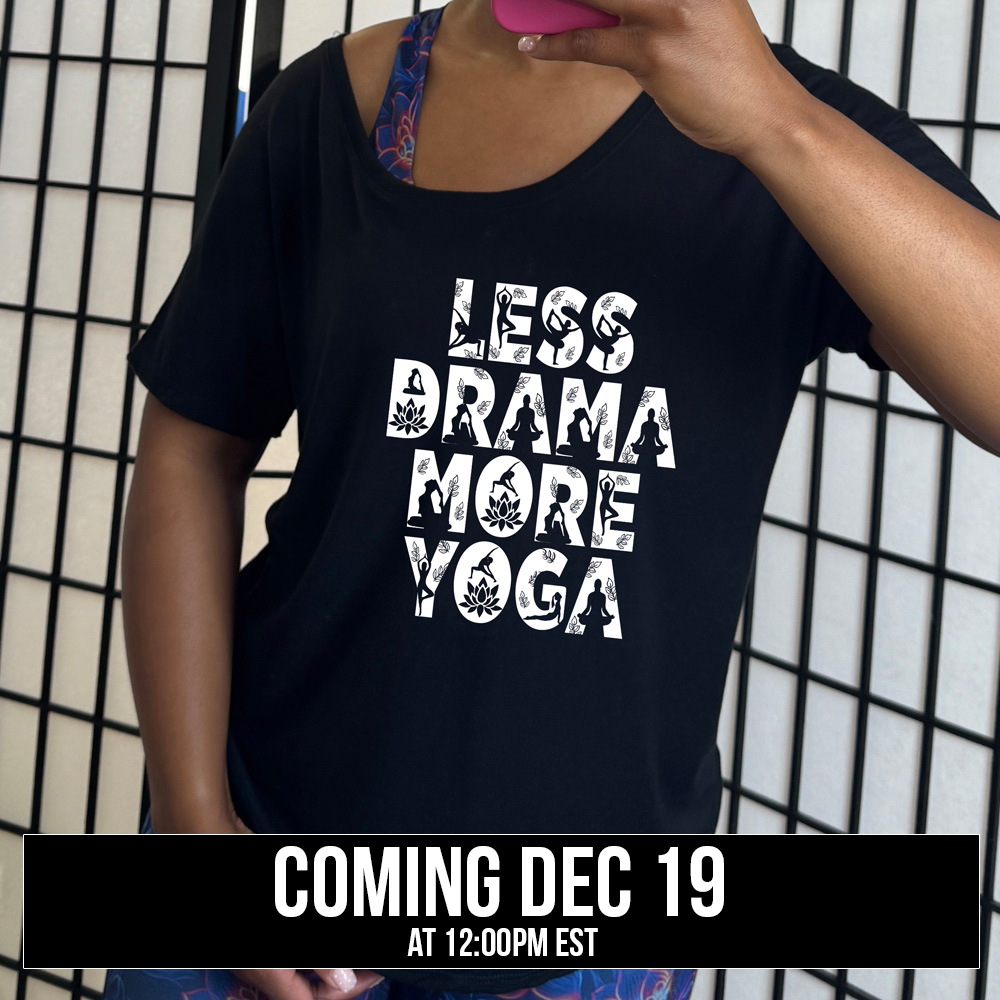 black slouchy shirt with the words "less drama more yoga" on it, and within each letter there are silhouettes of people doing yoga poses as well as some lotus flowers and some leaves