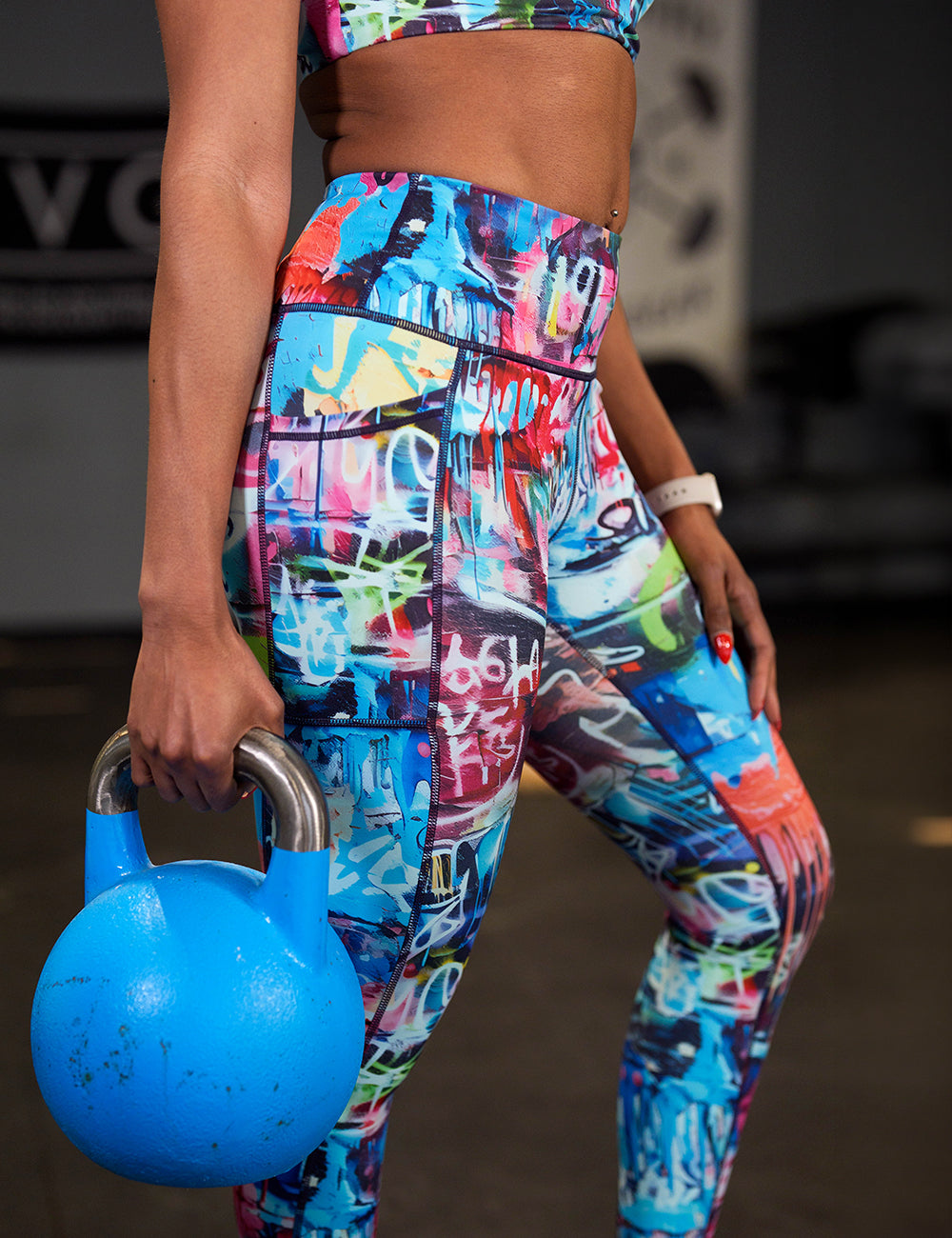 model wearing the full length graffiti pattern leggings holding a kettle bell