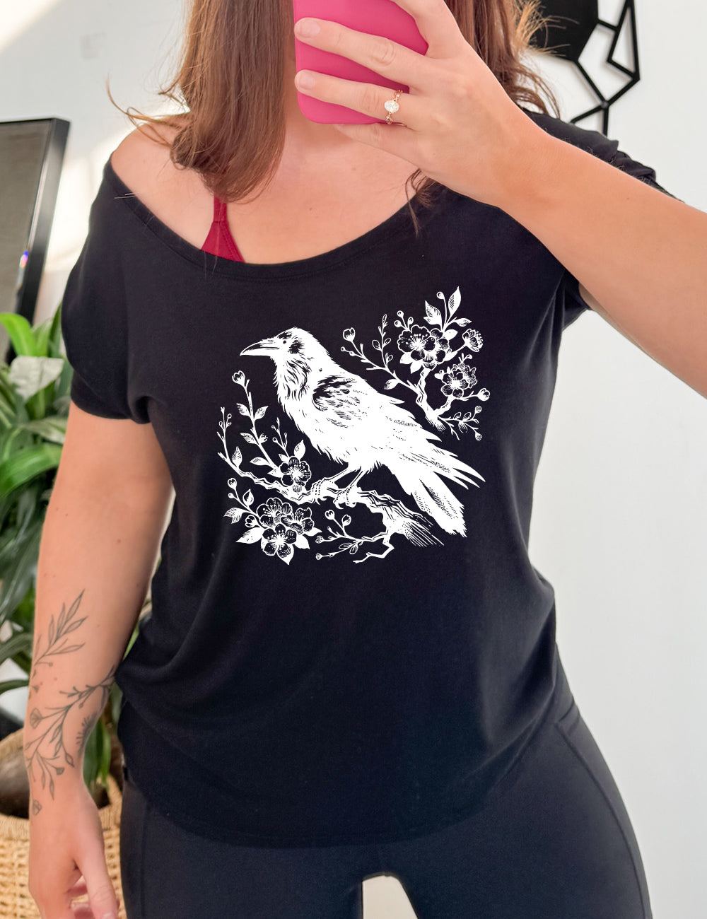 black slouchy tee with crow on flowery branch graphic on it