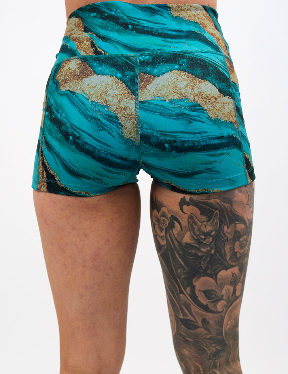 back of the 2.5 inch blue ocean with gold streaks patterned shorts against a white background