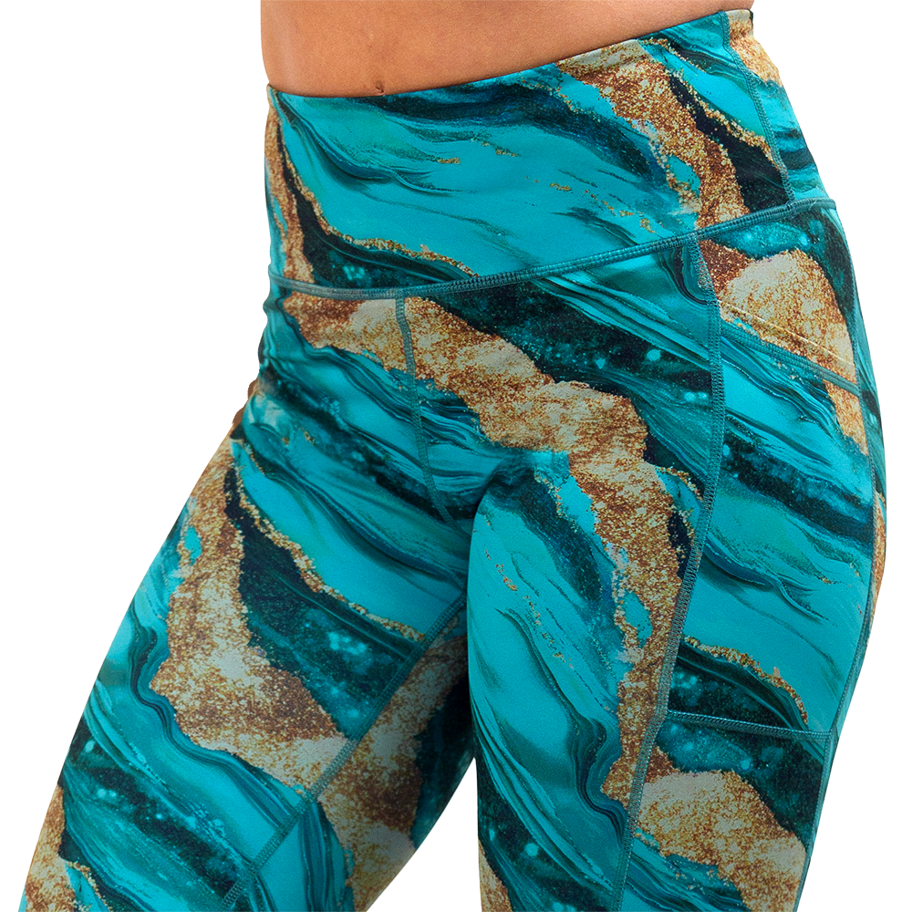 close up of blue ocean with gold streaks patterned leggings