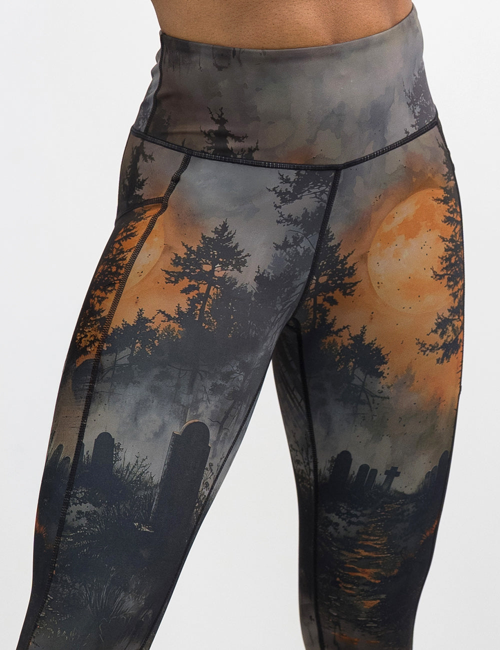 front of the dark cemetery with a full moon leggings against a white background