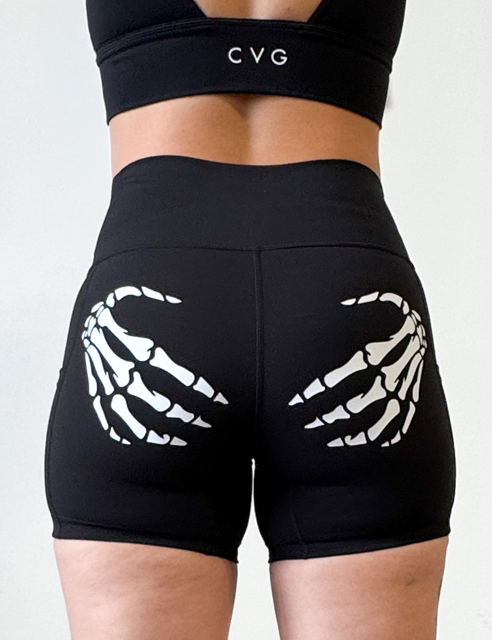 white skeleton hands on back of black shirts