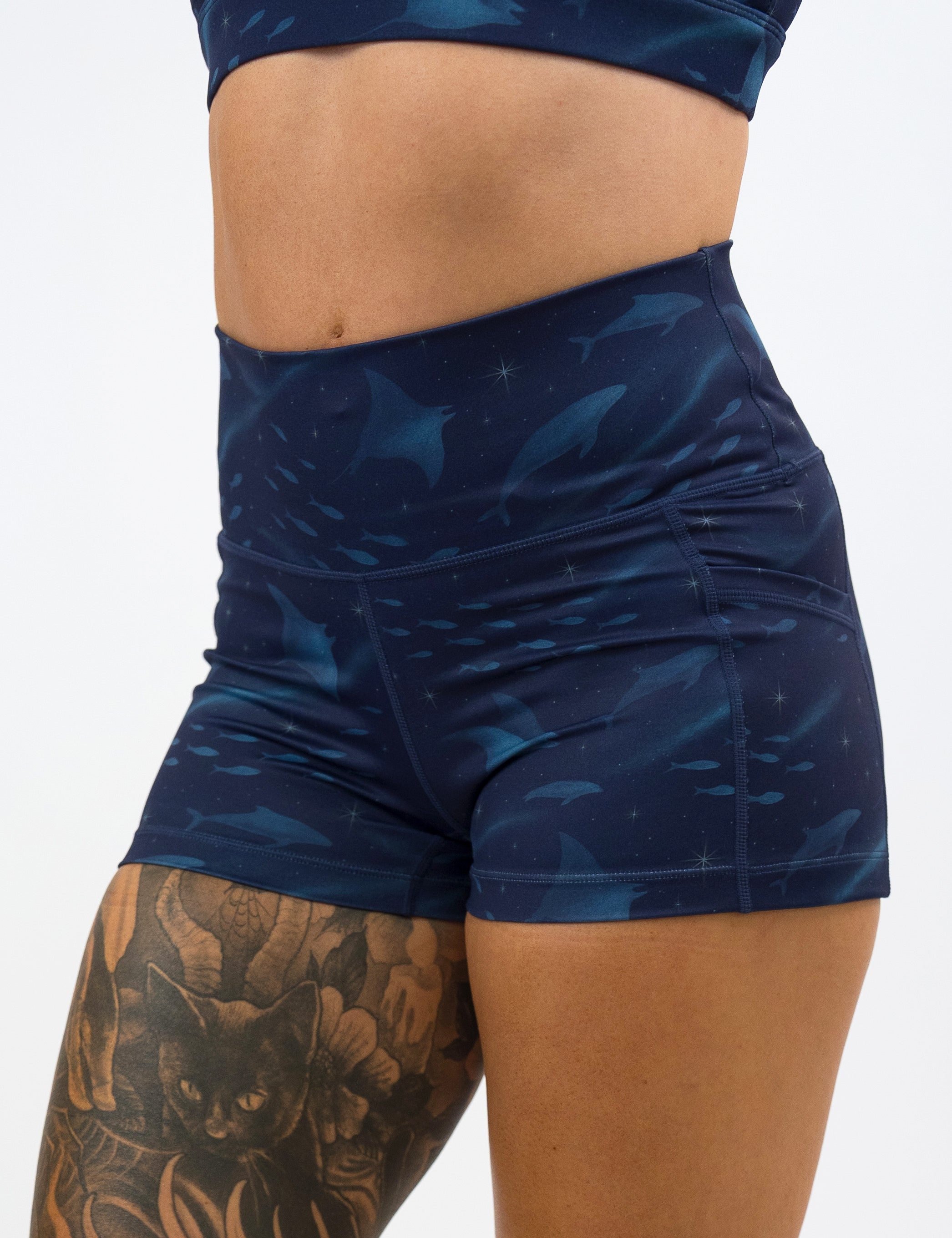 front of the 2.5 inch dark blue ocean filled with sting rays, whales, and fish shorts against a white background