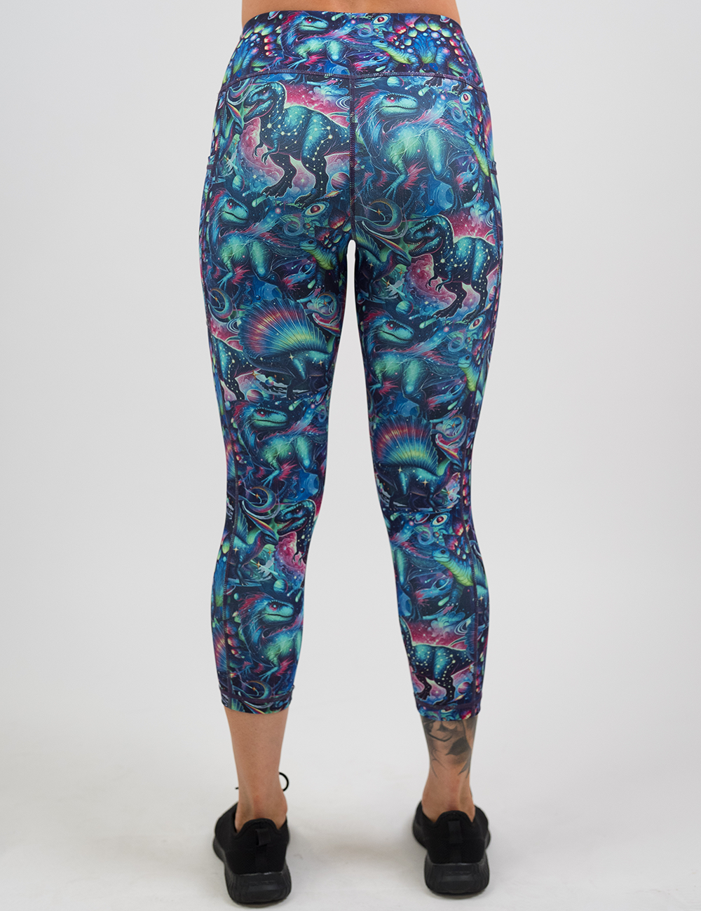 back of the colorful dinosaur capri leggings against a white background