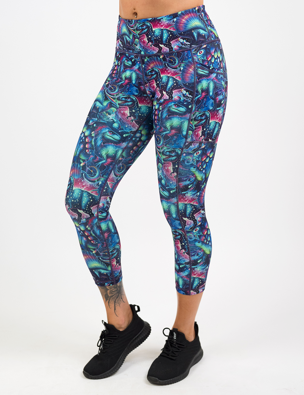 model wearing the capri colorful dinosaur leggings against a white backgound