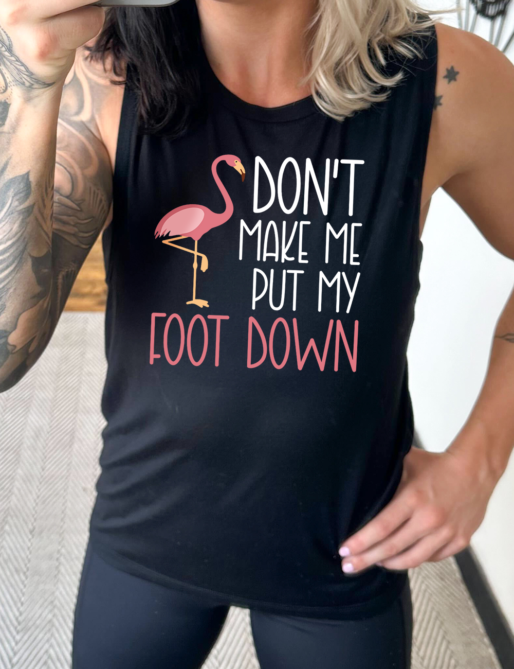 black muscle tank with the words "don't make me put my foot down" on it, with the graphic of a flamingo next to the words, with its foot raised