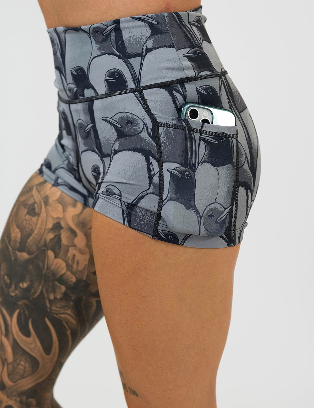 close up of the 2.5 inch penguin patterned shorts with a phone in its pocket