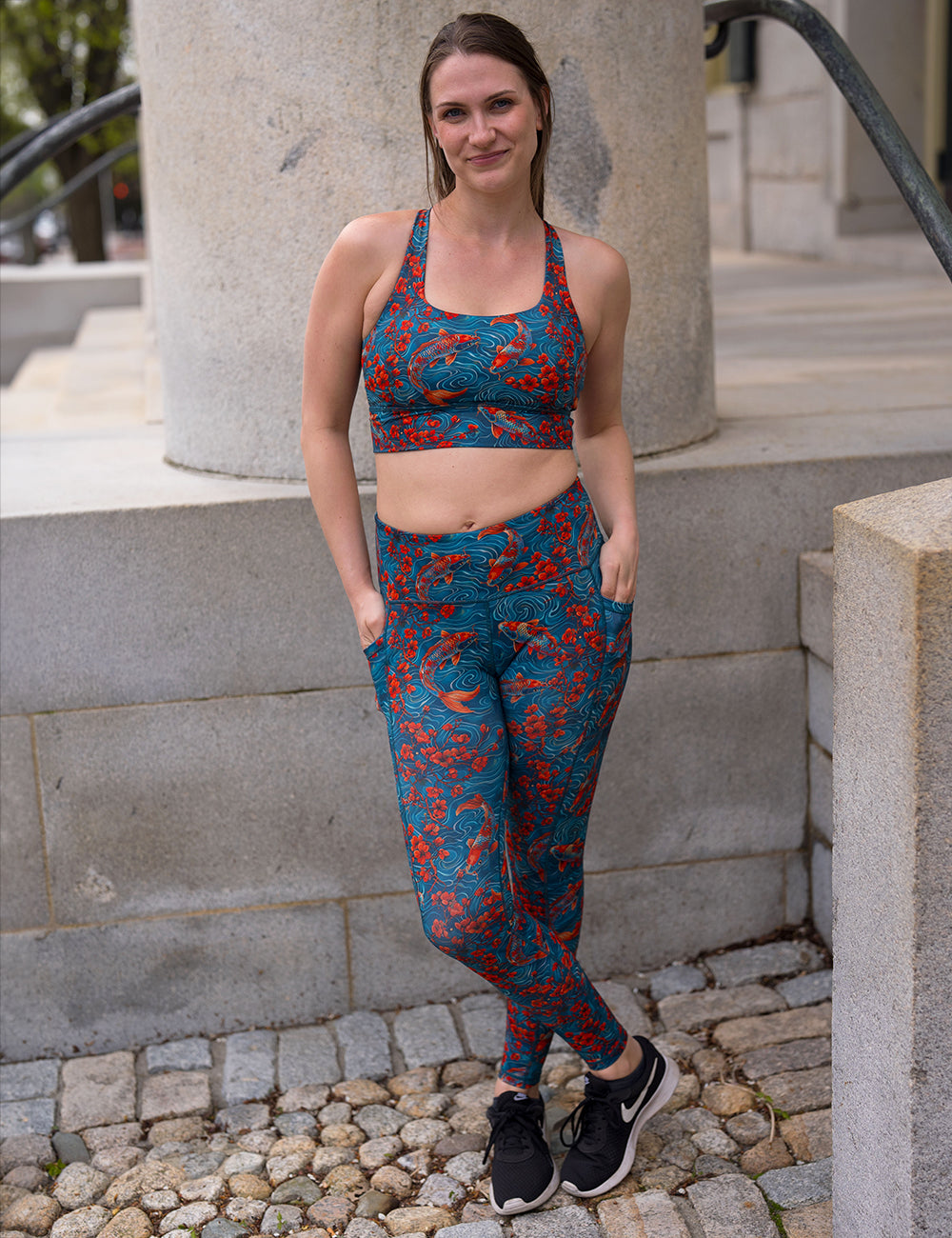 model wearing the koi fish swimming with orange flowers full length leggings